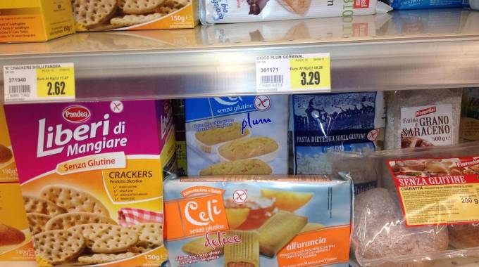 Pane, pasta, dolcetti e crackers senza glutine sullo scaffale di un supermercato (Ansa)