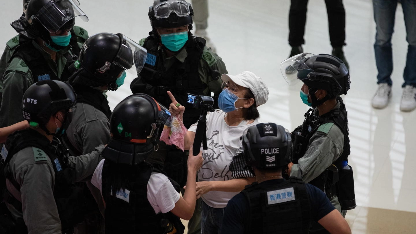 Una donna protesta con gli agenti a Hong Kong (Ansa)