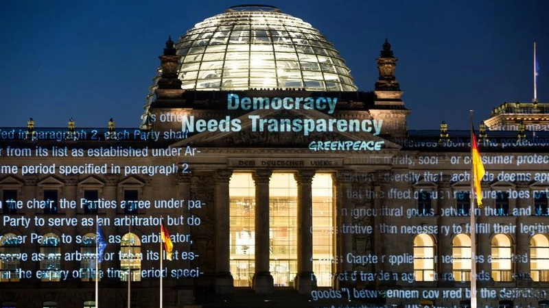 Attivisti di Greenpeace proiettano sul German Reichstag parte del testo del Ttip (Ansa)
