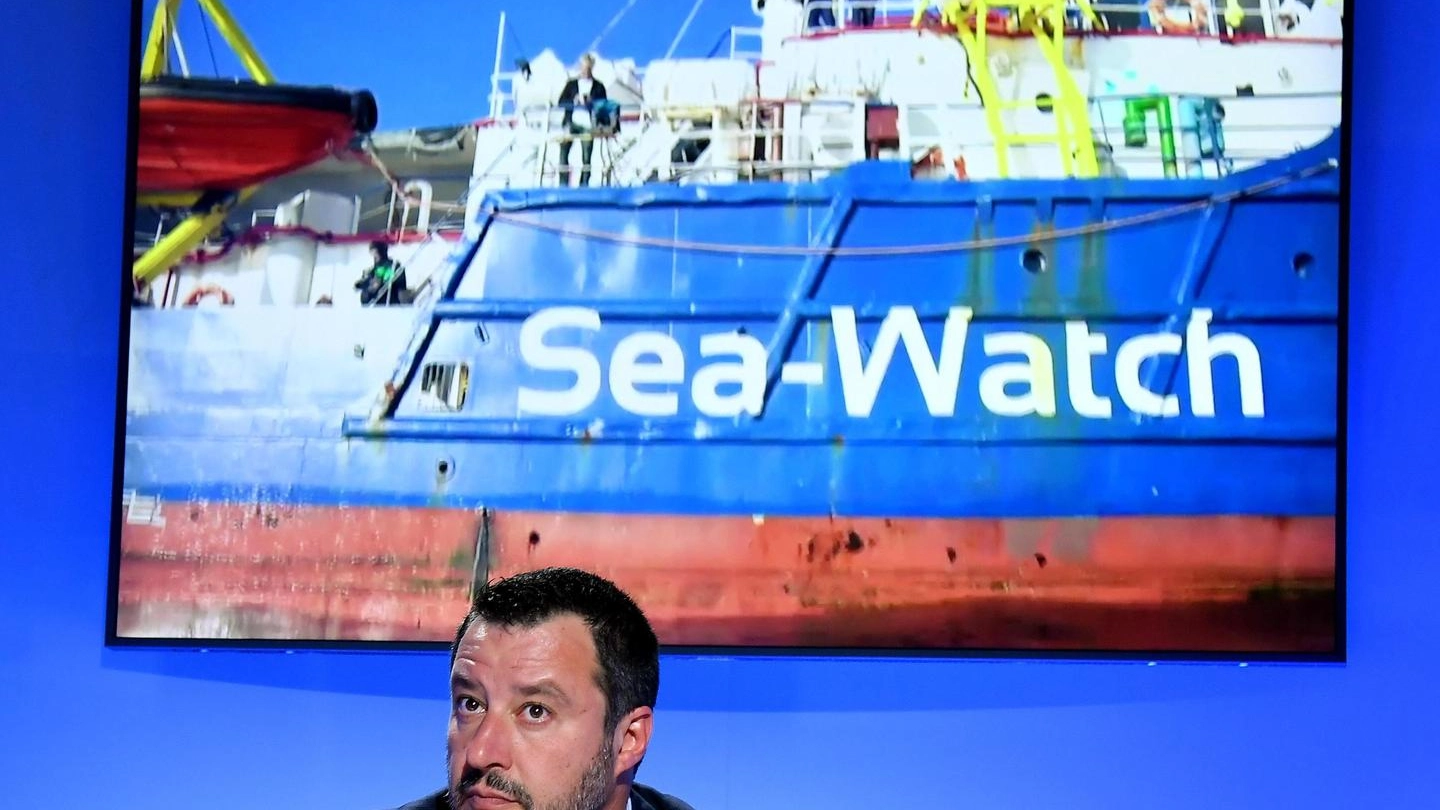 Il ministro dell'Interno Matteo Salvini con dietro una foto della Sea Watch (Ansa)