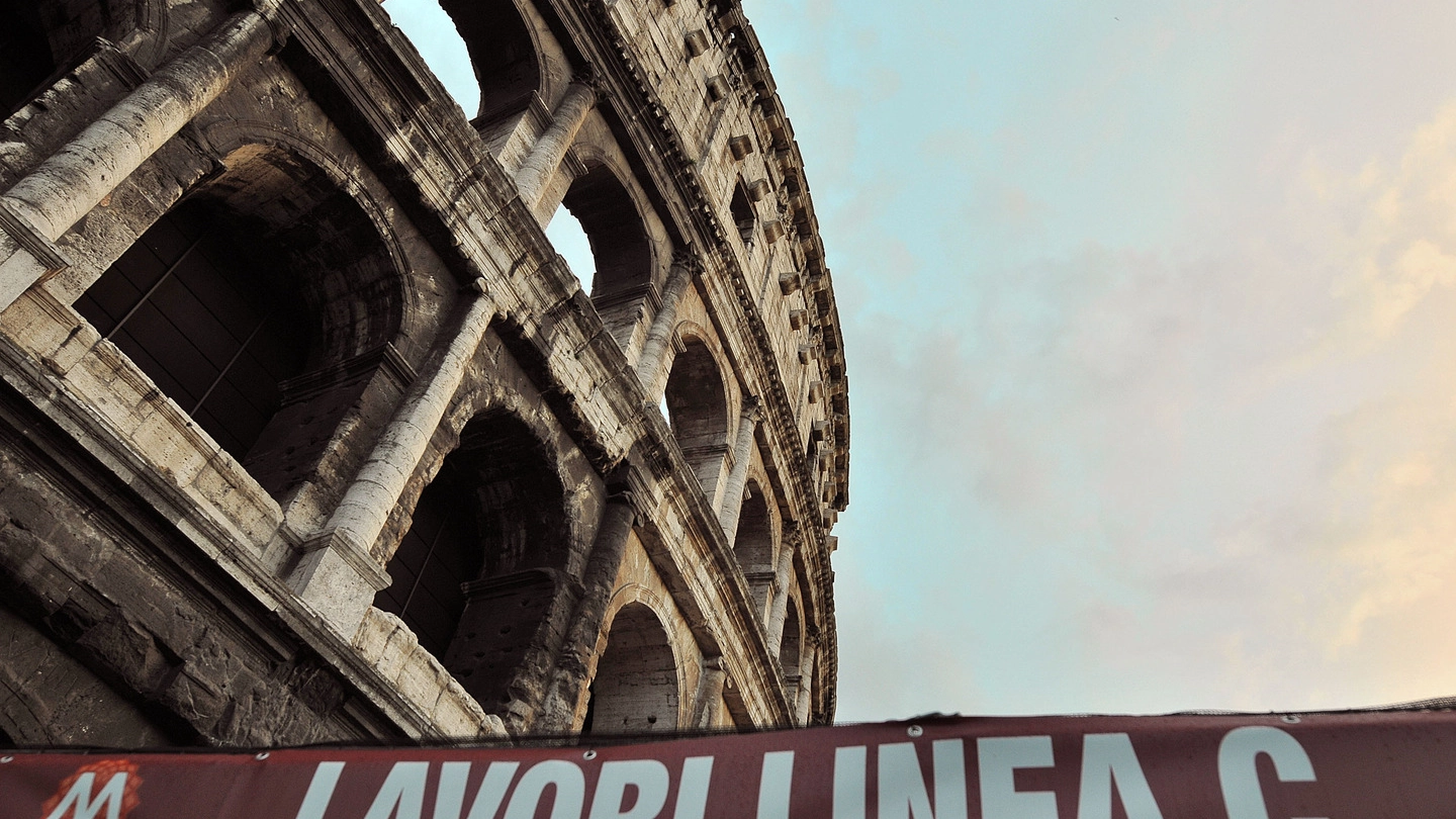 Un cartello che indica i lavori per la metro C davanti al Colosseo (Ansa)