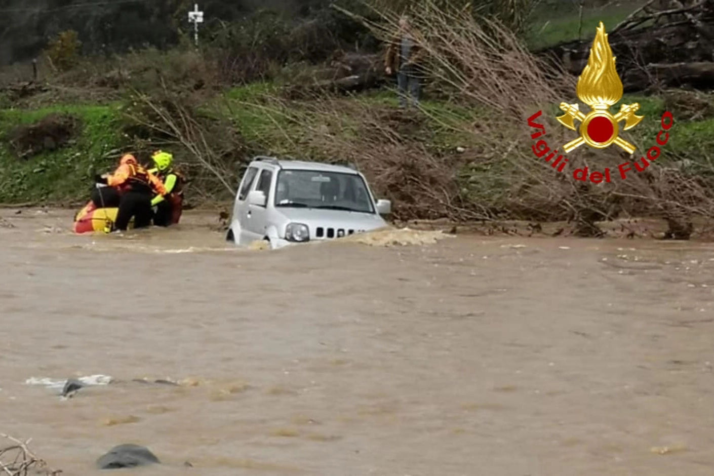 L'auto, con due persone a bordo, rimasta intrappolata  nel torrente Maiano (Ansa)