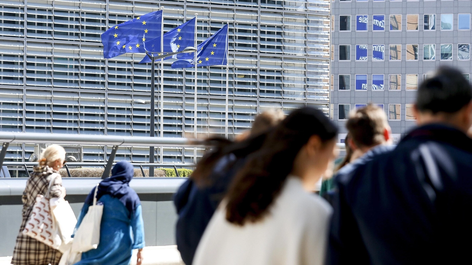 Bandiere dell'Ue sventolano vicino alla sede della Commissione a Bruxelles (Ansa)