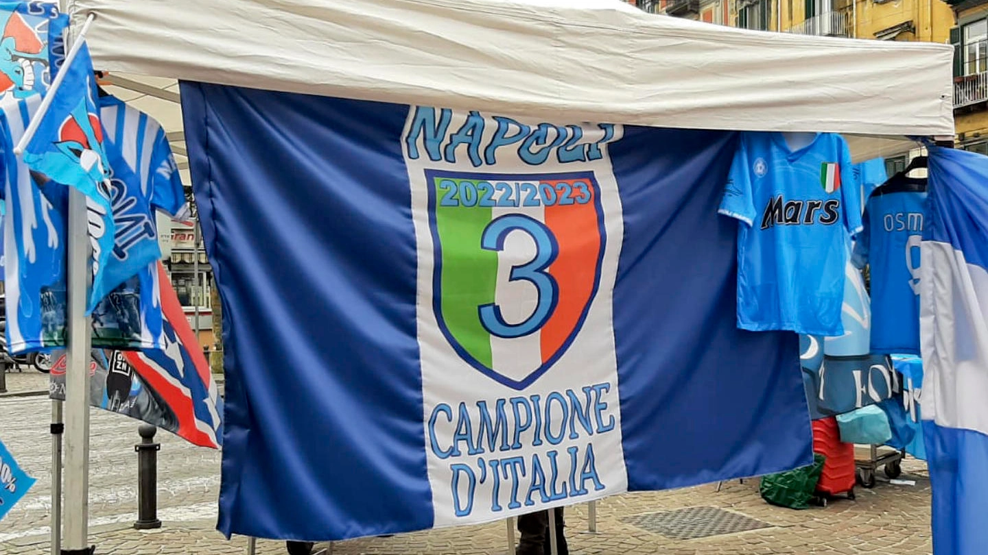 Una bacarella a Napoli espone una bandiera con il terzo scudetto (Ansa)