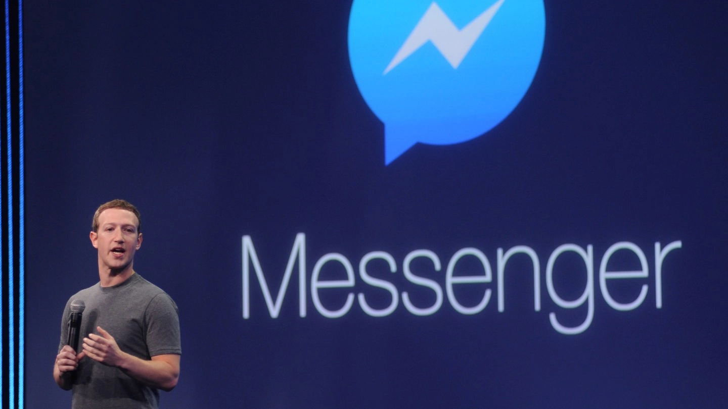 Mark Zuckerberg e il logo di Messenger (Afp)
