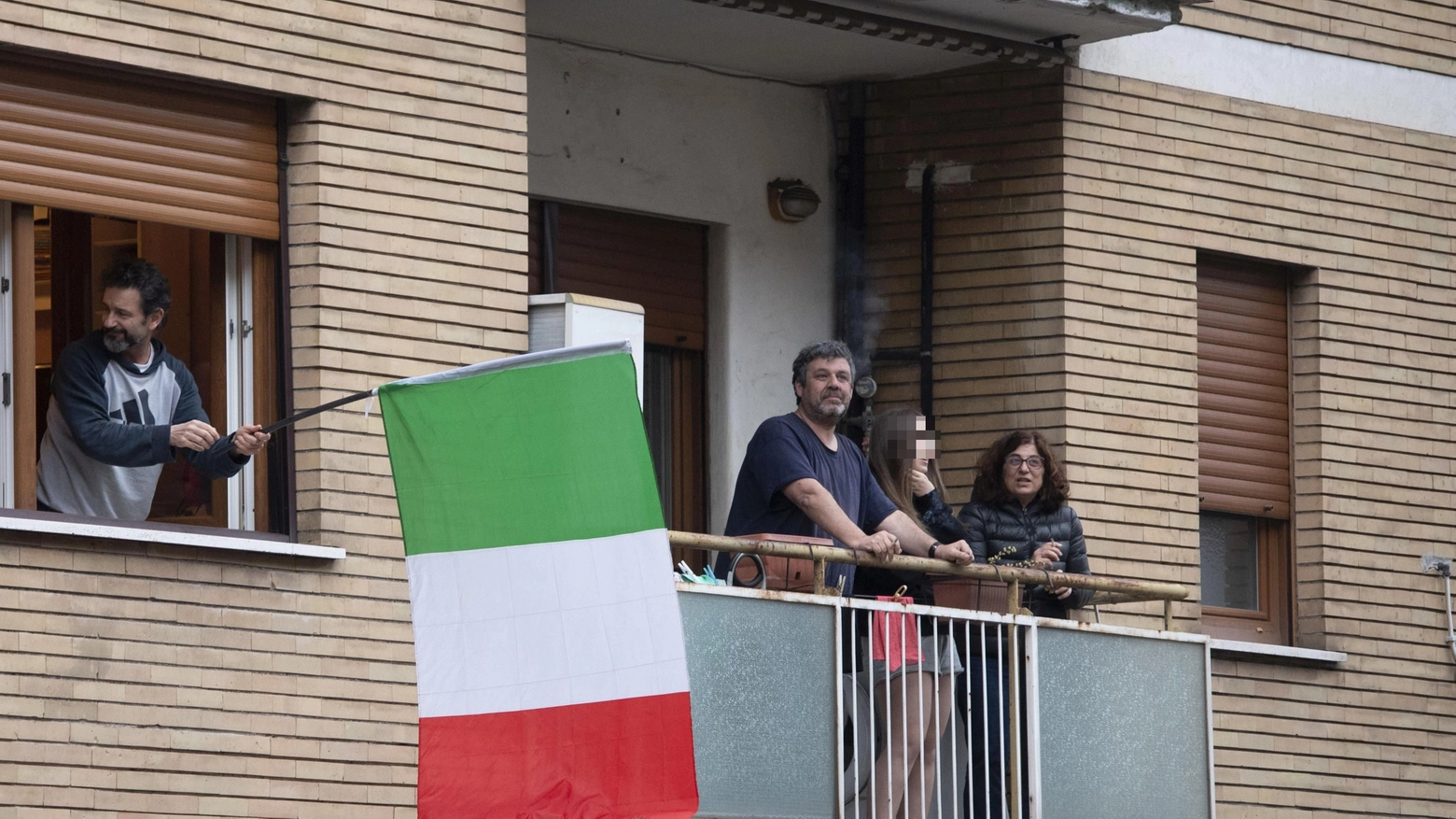 Bandiere tricolori e Inno d'Italia per combattere la paura del Coronavirus (Ansa)