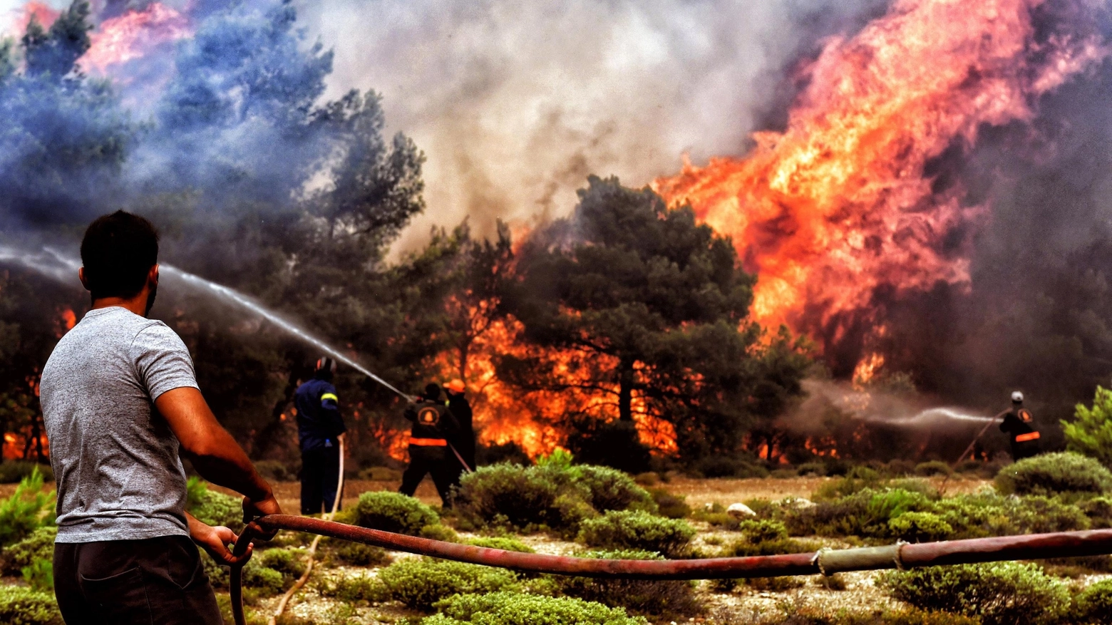 Pompieri e volontari impegnati a domare l'incendio in Grecia (Ansa)