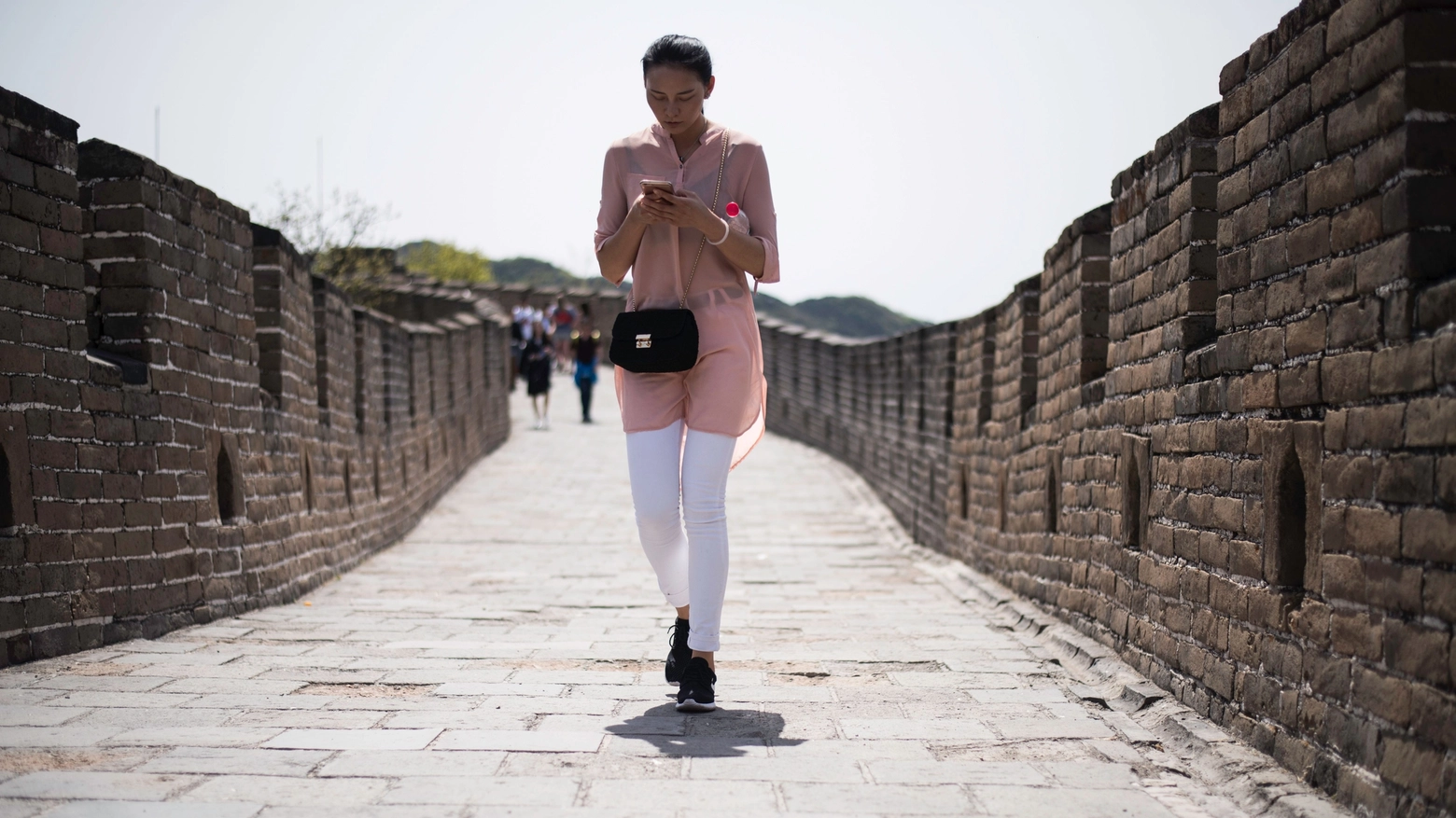 Incollati allo smartphone anche sulla grande muraglia cinese (Afp)
