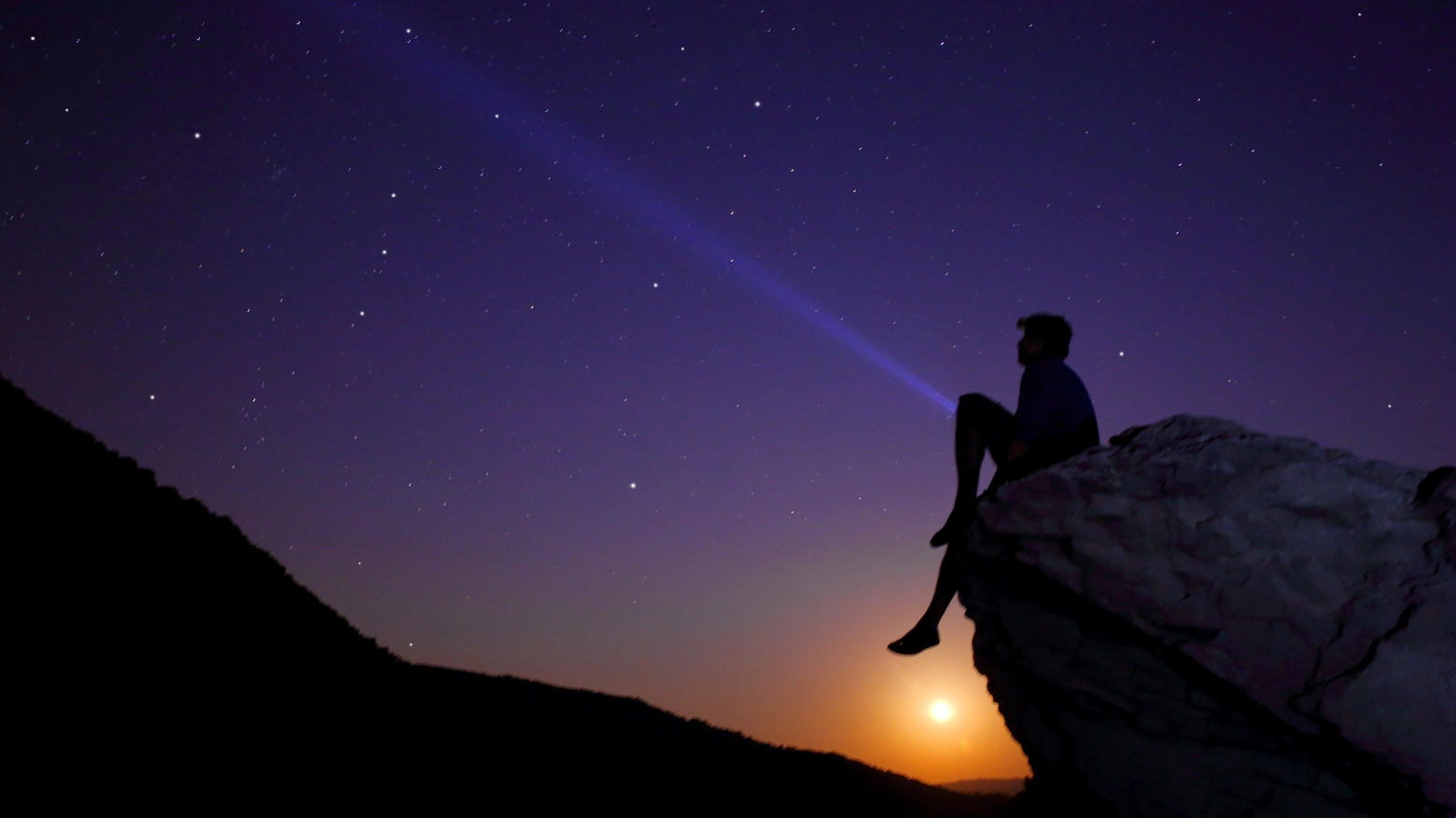 Un ragazzo seduto guarda le stelle