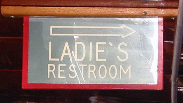 Un cartello in un locale indica il bagno delle donne (ladies), ma l'apostrofo è sbagliato