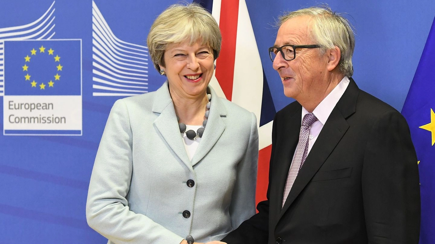 Stretta di mano tra Theresa May e Jean-Claude Juncker (Afp)