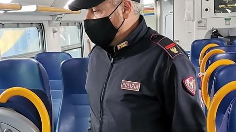 Un agente della Polfer impegnato nei controlli su un treno regionale