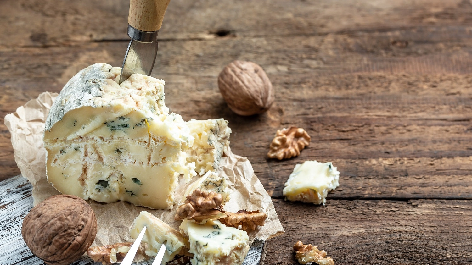 Blue cheese dorblu, gorgonzola, roquefort with walnuts on wooden background. banner, menu, recipe place for text