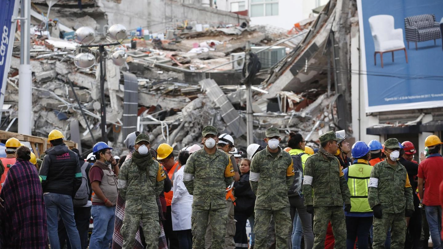 Soldati e soccorritori fermi in strada dopo l'ennesima scossa a Città del Messico (Ansa)