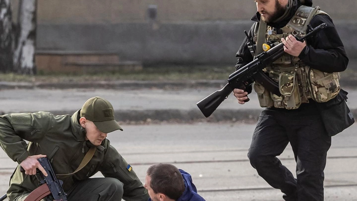 Uomini della sicurezza ucraina controllano le condizioni della gente dopo un bombardamento