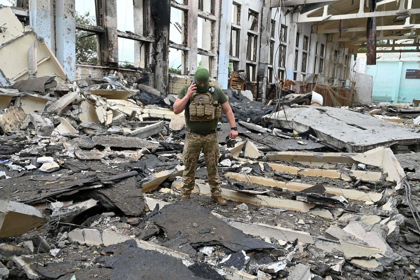 Un militare ucraino tra le macerie di un edificio dell'Università di Kharkiv (Ansa)
