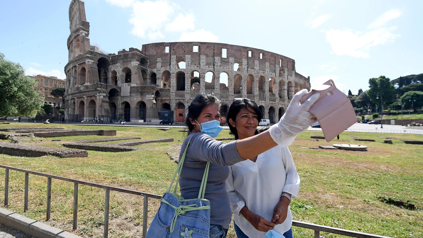 Roma, due amiche si scattano un selfie davanti al Colosseo (Ansa)