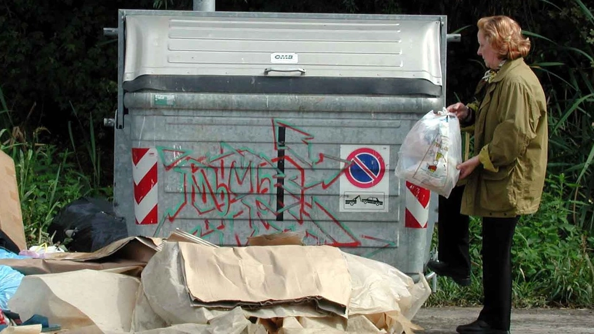 Un cittadino mentre getta i rifiuti (Foto d'archivio)