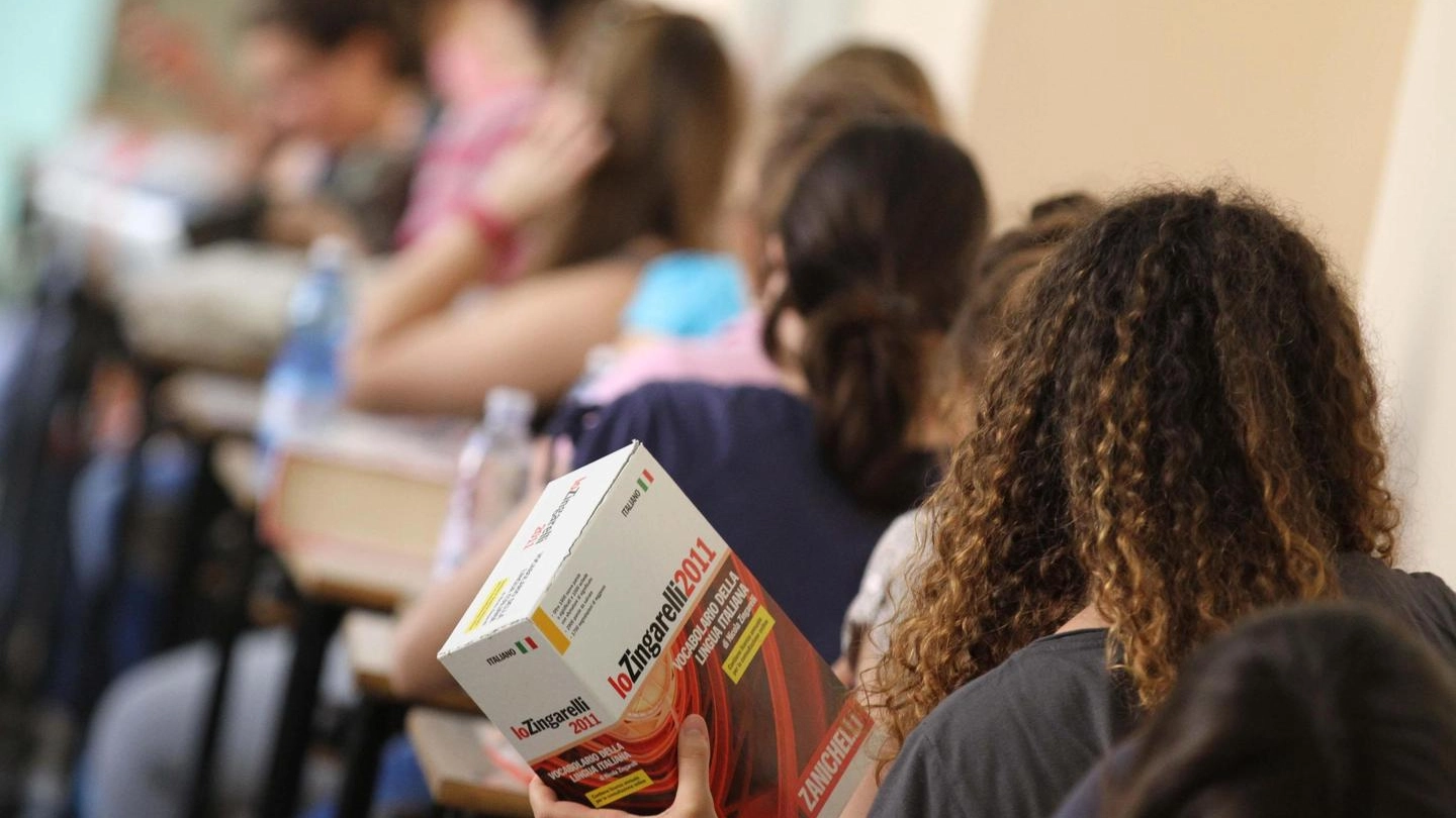 Una studentessa con un dizionario d'italiano durante gli esami di maturità (Newpress)