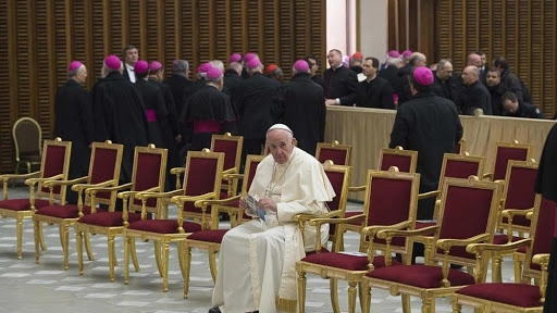 Il Papa seduto da solo e i vescovi alle sue spalle