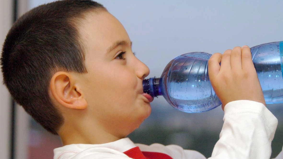 Un bimbo beve da una bottiglia di acqua minerale (Radaelli)
