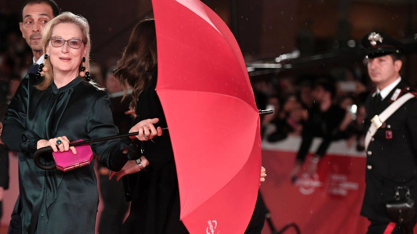 Meryl Streep sul red carpet con un gigantesco ombrello rosso (Afp)
