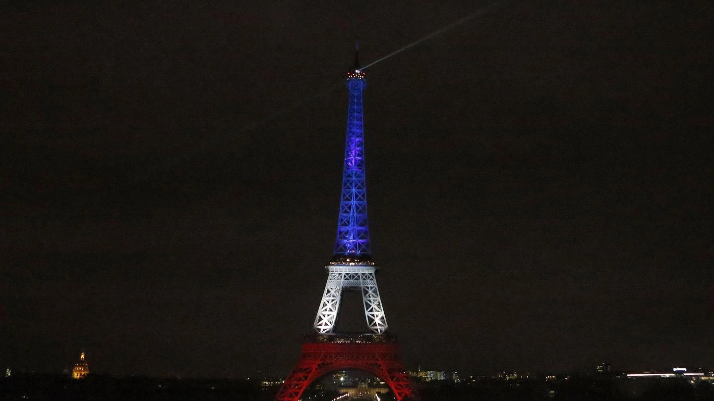 L'illuminazione della Tour Eiffel dopo la tragedia che venerdì ha colpito la Francia (Ansa