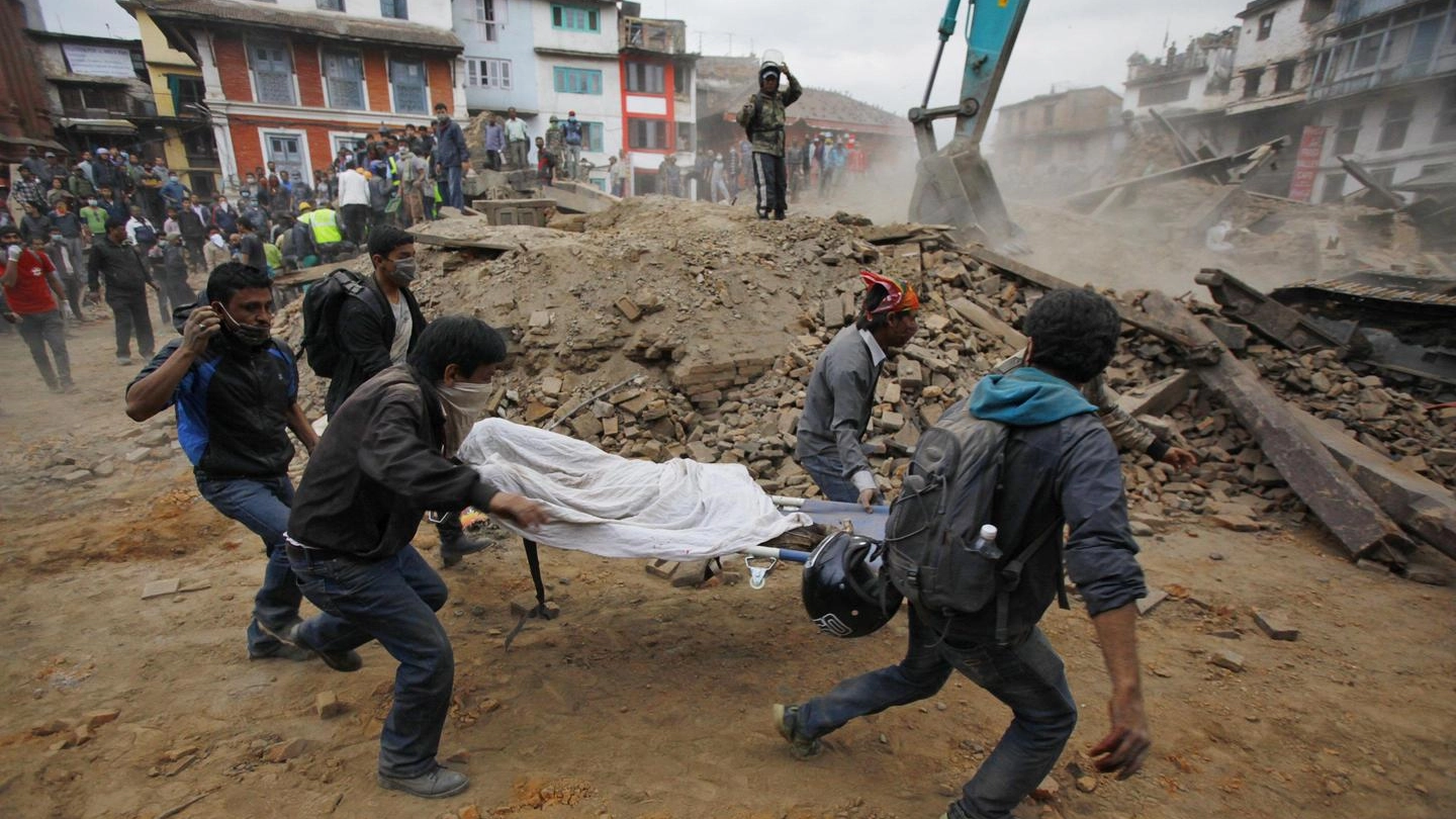 Volontari trasportano il corpo di una vittima del sisma di Katmandu, Nepal (Ansa)