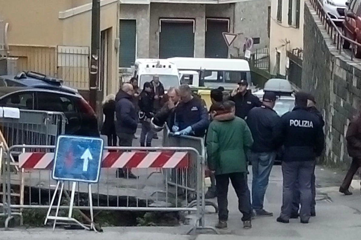 Genova, polizia e curiosi davanti alla voragine dove è morto un 87enne (Ansa)