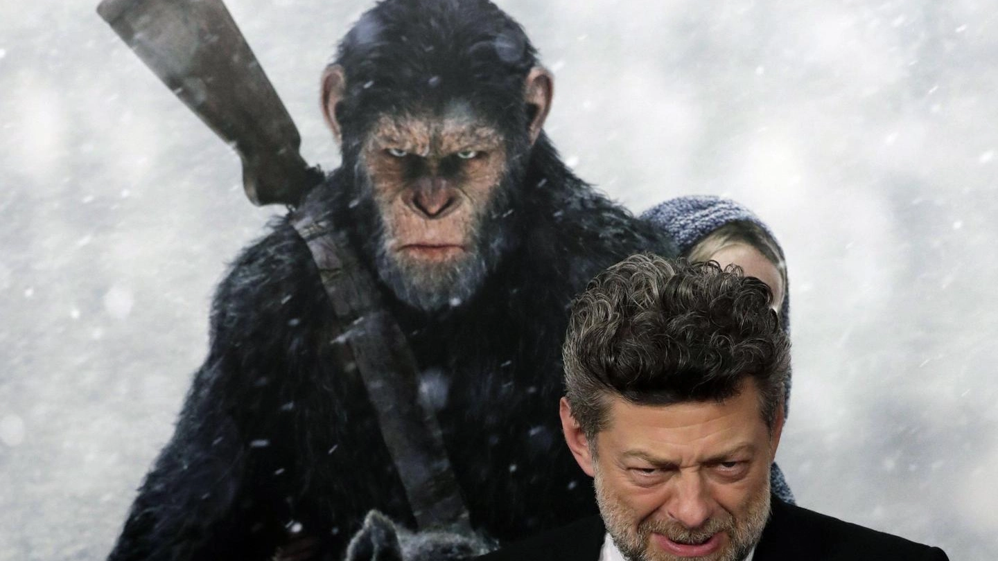 Andy Serkis e il cartellone di 'The War, il pianeda delle scimmie' (Ansa)