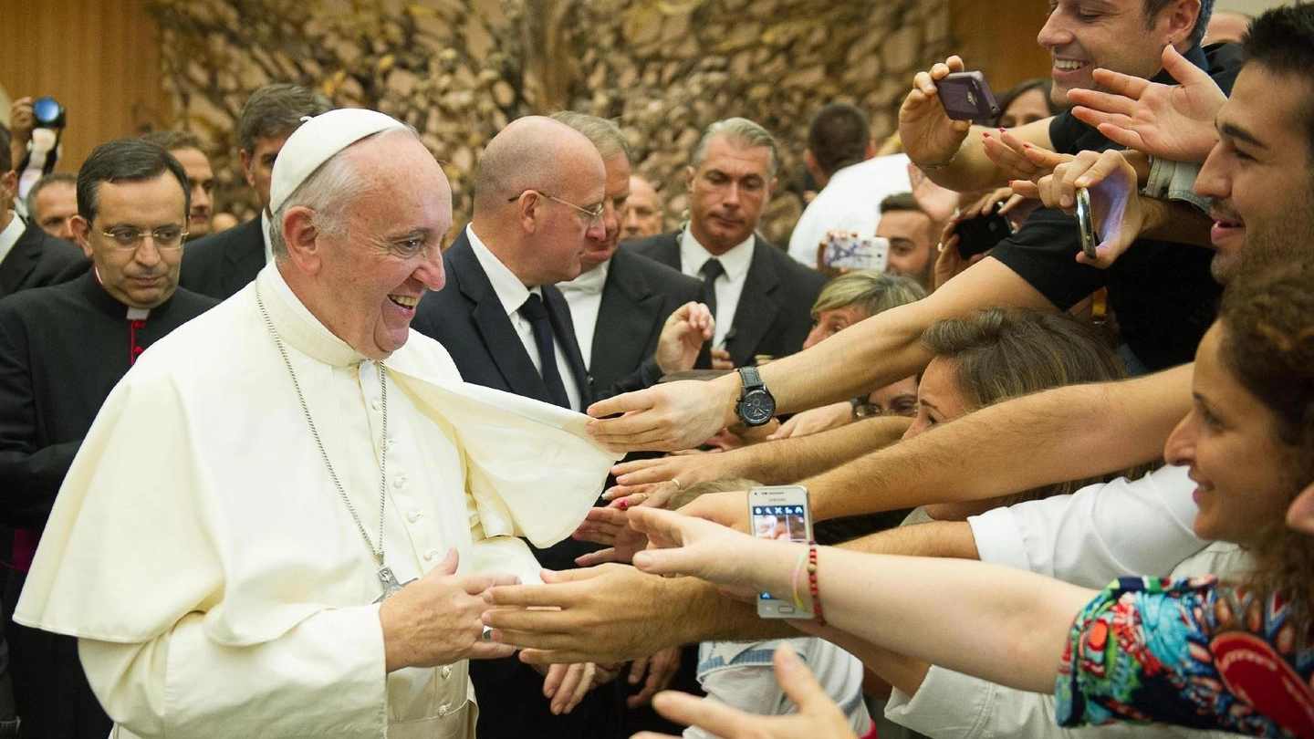 Papa Francesco con alcuni fedeli (Ansa)