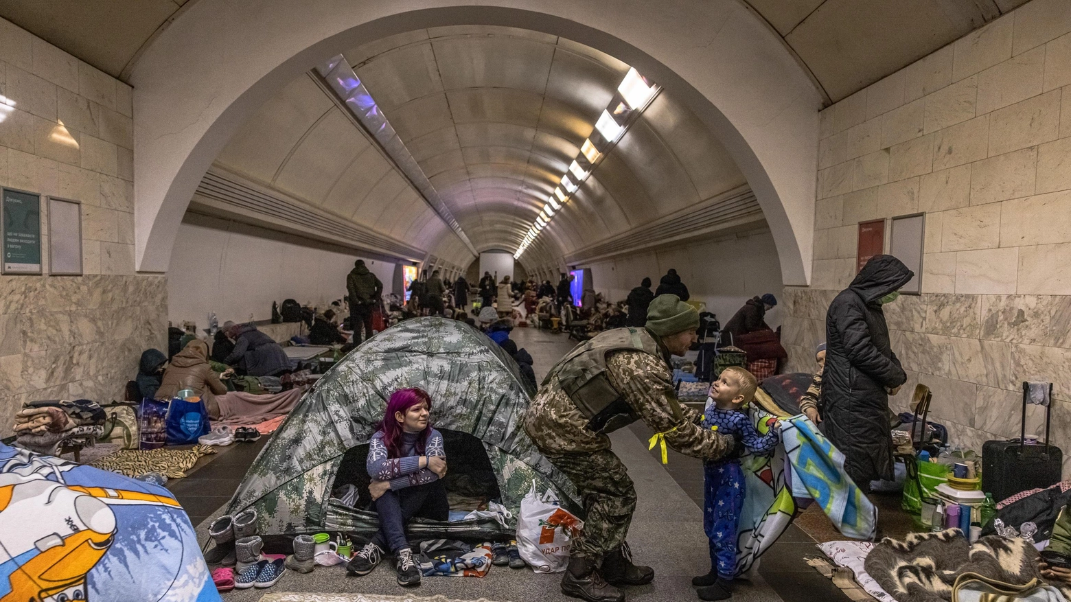 Un soldato ucraino saluta il figlio al riparo con la mamma nella metropolitana di Kiev 