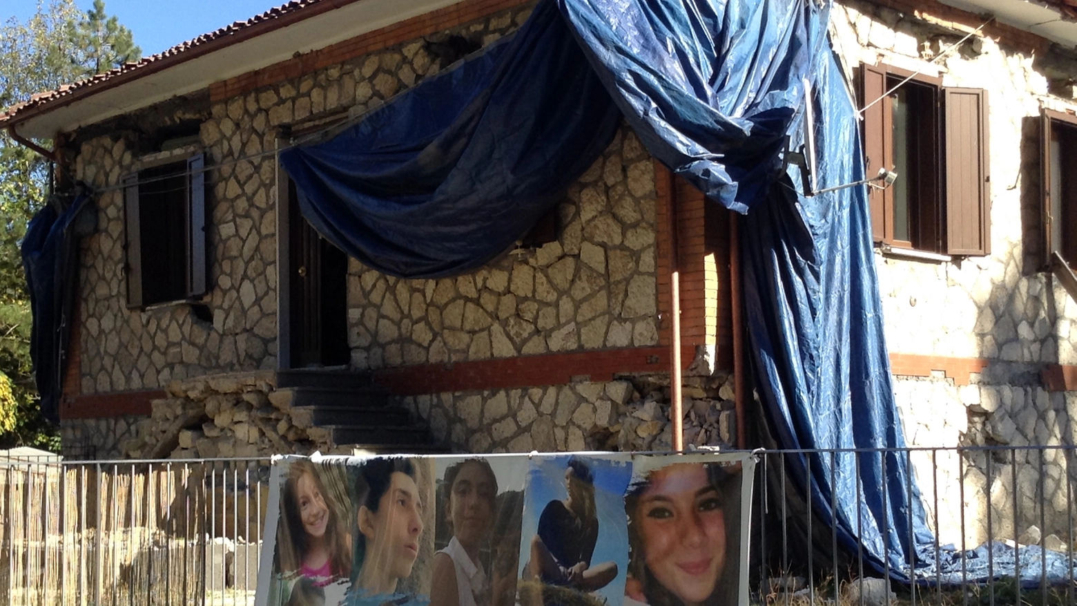 Lo striscione con le foto di alcune giovani vittime a Pescara del Tronto