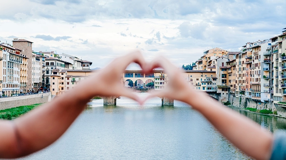 Loving couple making heart with her hands in Florence