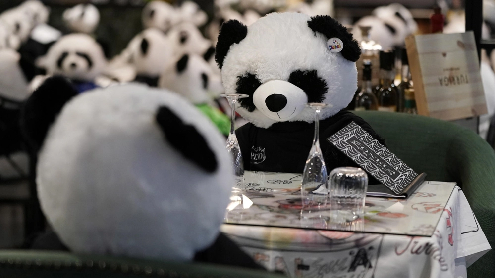 I panda seduti ai tavoli del ristorante Pino, in Germania - Foto: ANSA/EPA/RONALD WITTEK