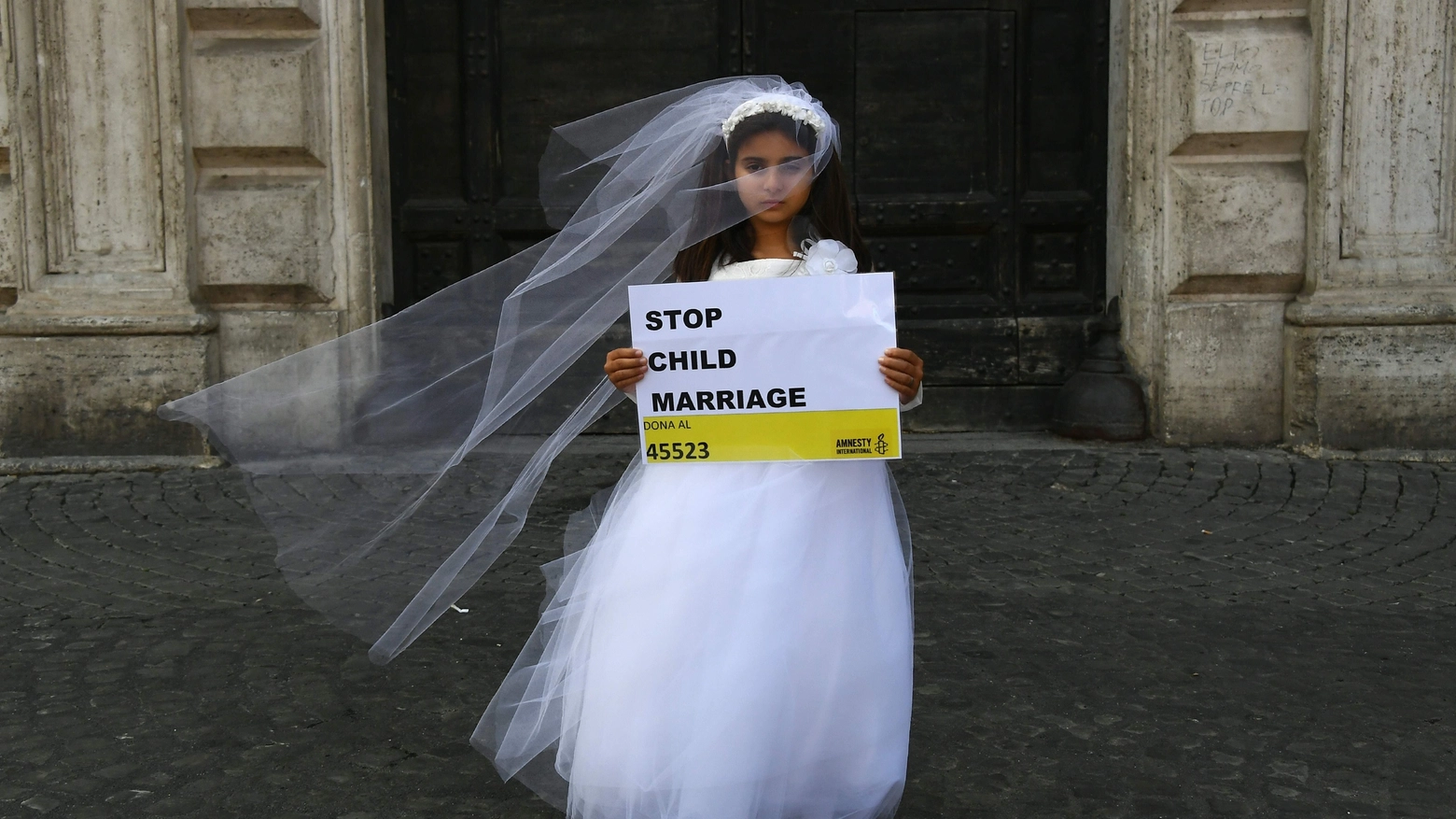 Una protesta organizzata da Amnesty International contro le spose bambine (Afp)