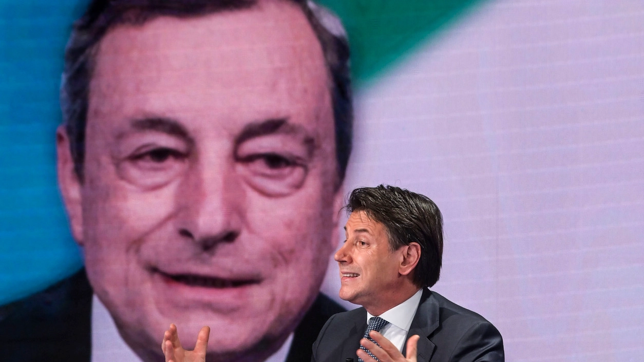 Il presidente del M5s Giuseppe Conte, 57 anni, con, sullo sfondo, Mario Draghi 