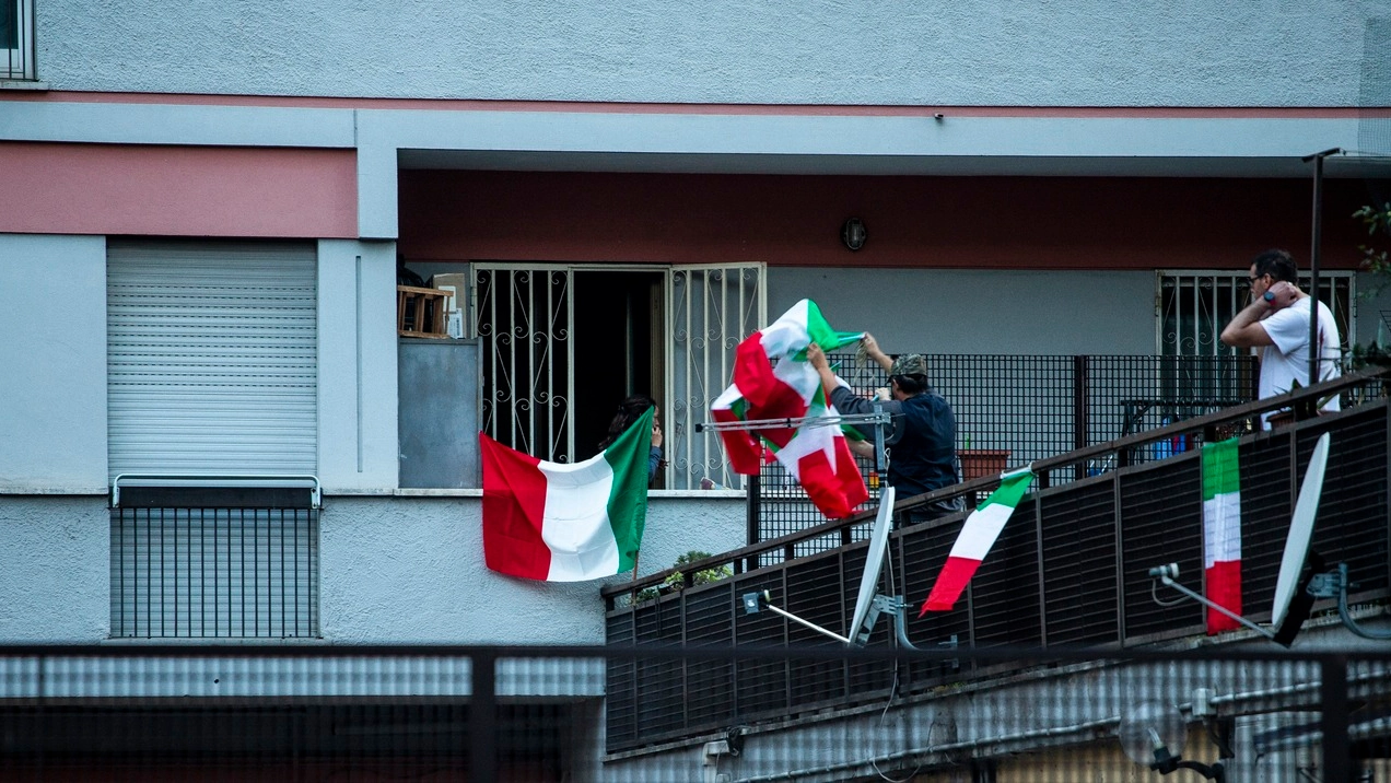 Bandiere italiane esposte dai residenti di Casal Bruciato (Lapresse)