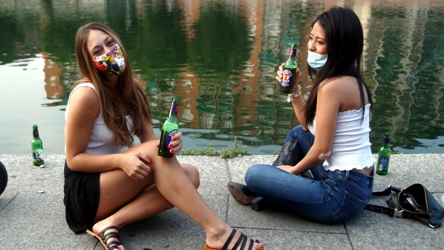 Due ragazze si rilassano sui Navigli, uno dei punti più affollati e a rischio di Milano