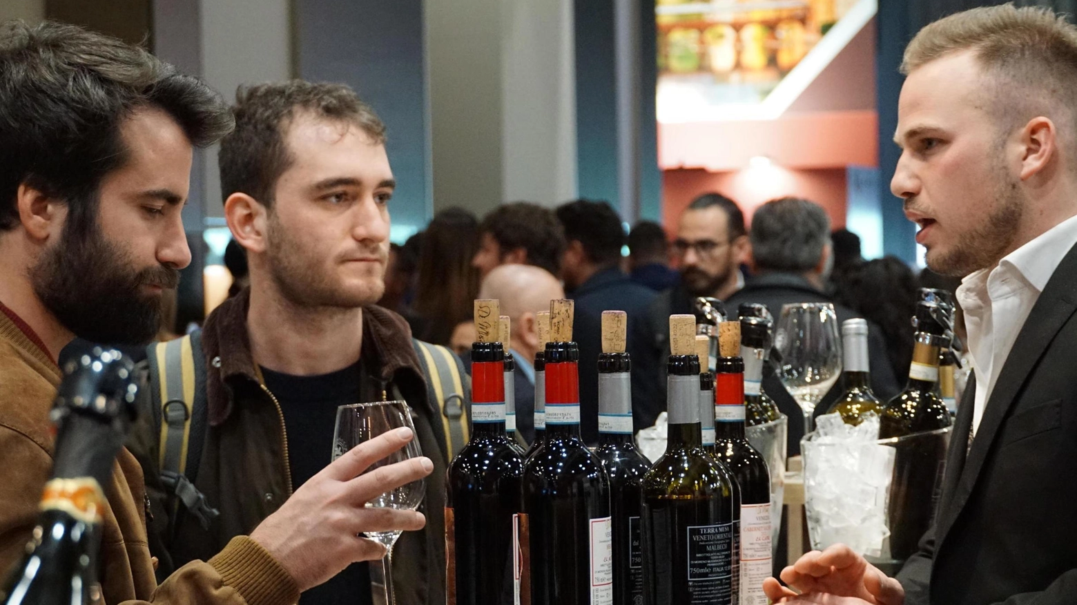 Appassionati di vino a uno stand di Vinitaly 2023