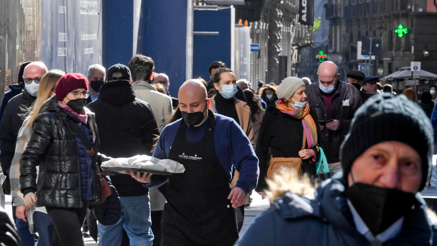 Passanti lungo le vie del centro a Napoli indossano mascherine anti covid