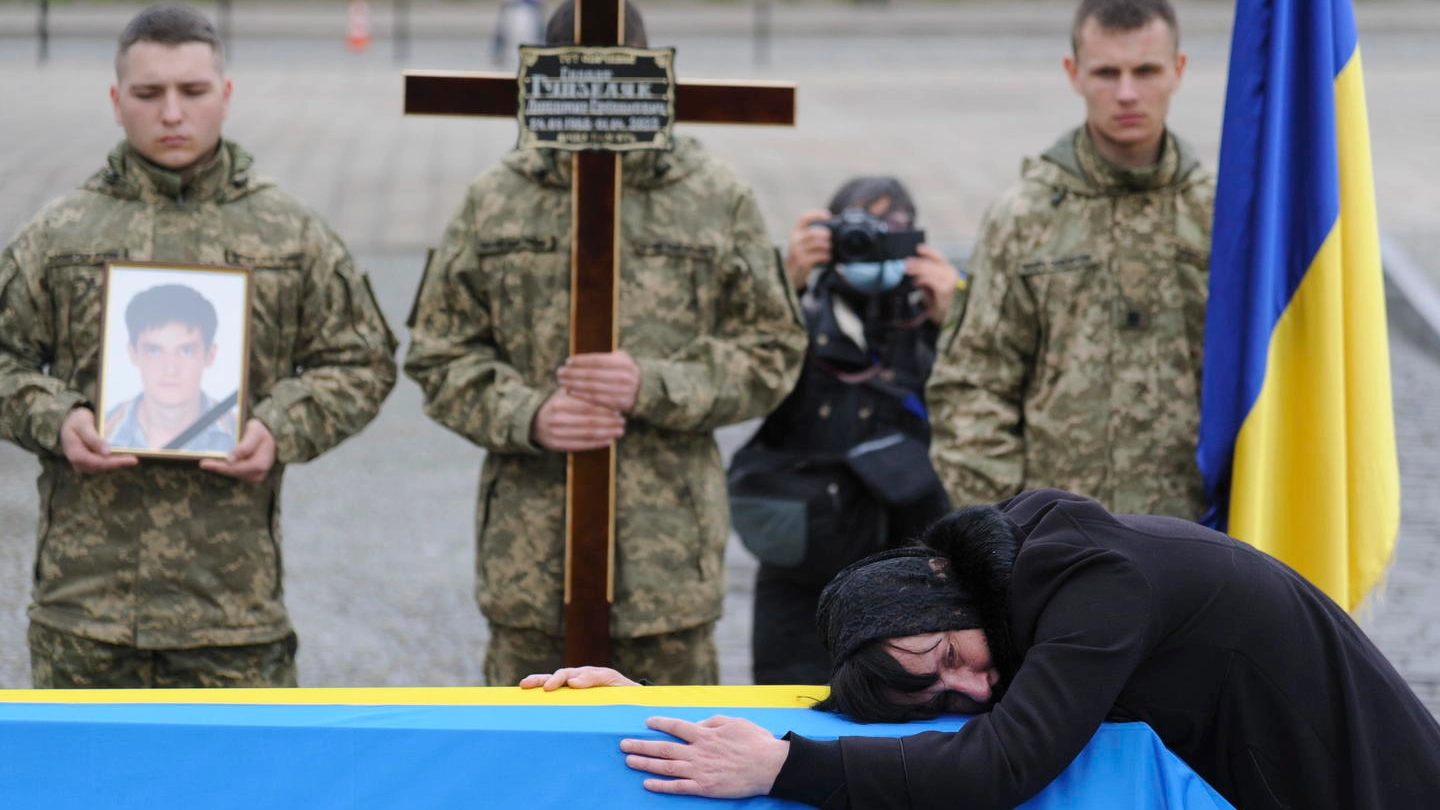 Una donna piange un soldato ucraino a Lviv (Ansa)
