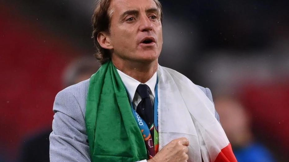 Roberto Mancini, 56 anni, avvolto nel tricolore sul prato di Wembley