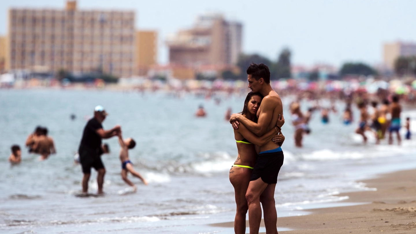 Una coppia si abbraccia sulla spiaggia di Malaga (Ansa) 