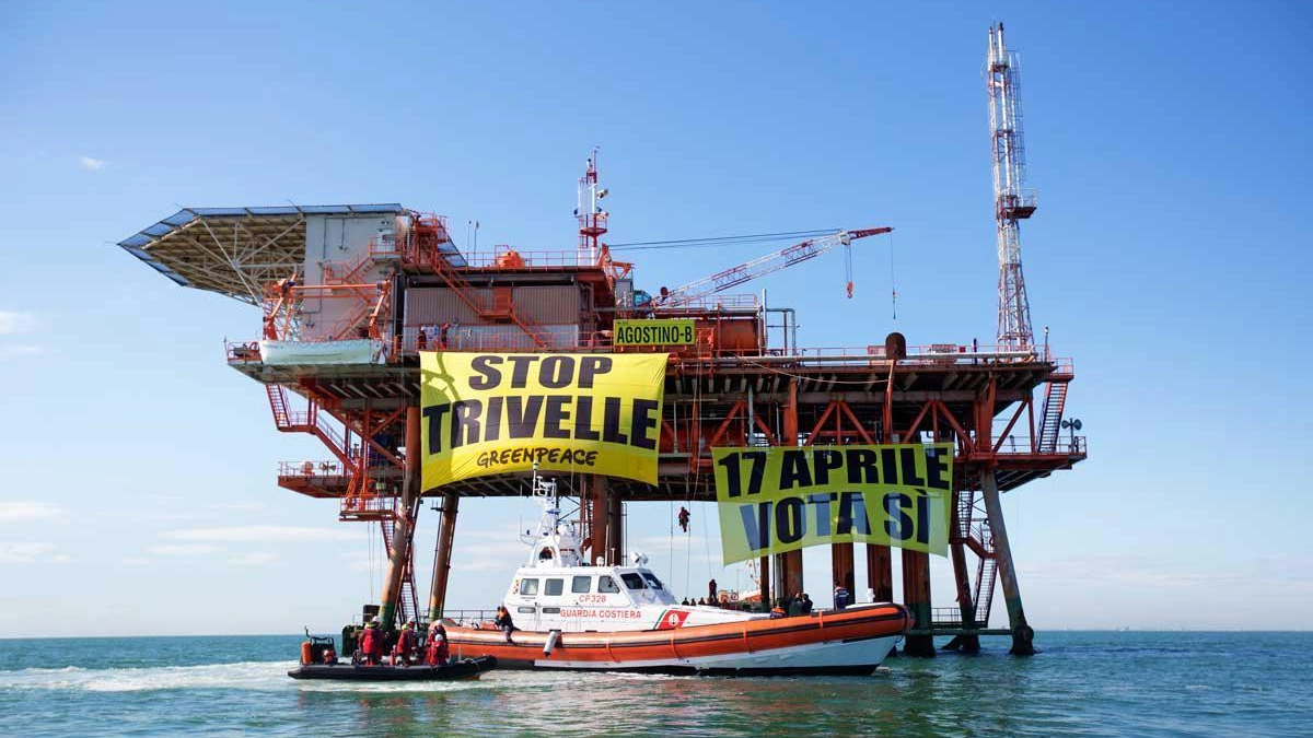 Una piattaforma e cartelli di Greenpeace anti trivelle