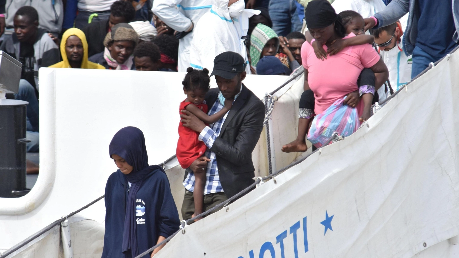 Migranti sbarcano dalla nave Diciotti (Ansa)