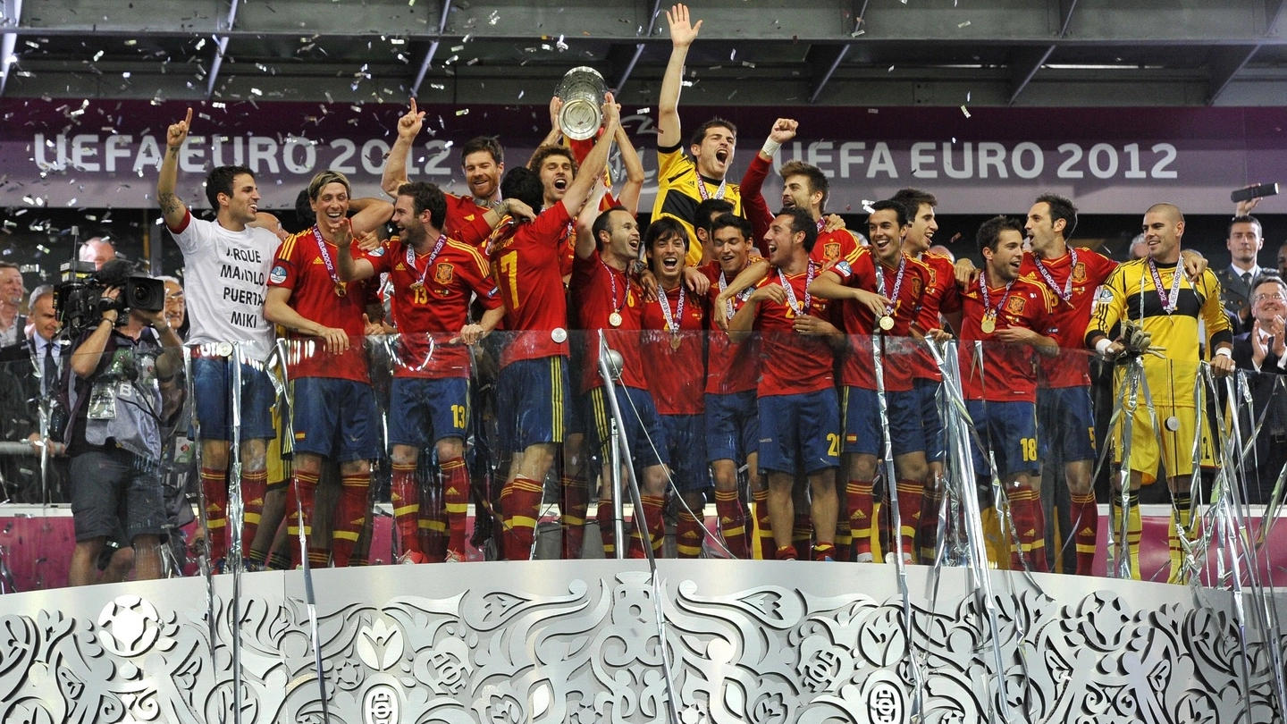 Tutta la gioia degli spagnoli che alzano la coppa al cielo di Kiev: i gol di Silva, Alba, Torres  e Mata fanno piangere Balotelli, inutilmente sconsolato dal ct azzurro Prandelli a fine partita 