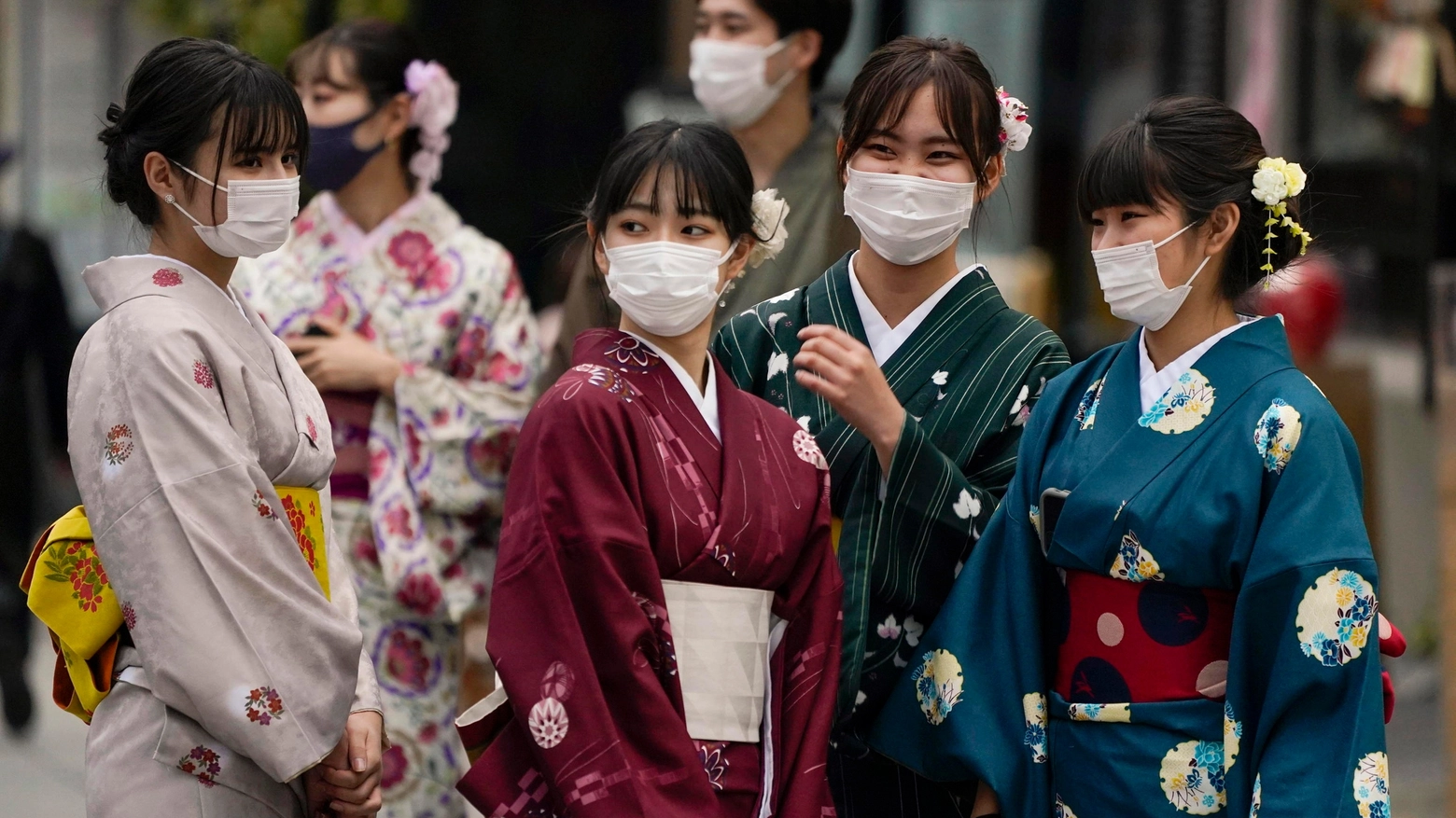 Un gruppo di ragazze giapponesi col tradizionale kimono e la mascherina (Ansa)