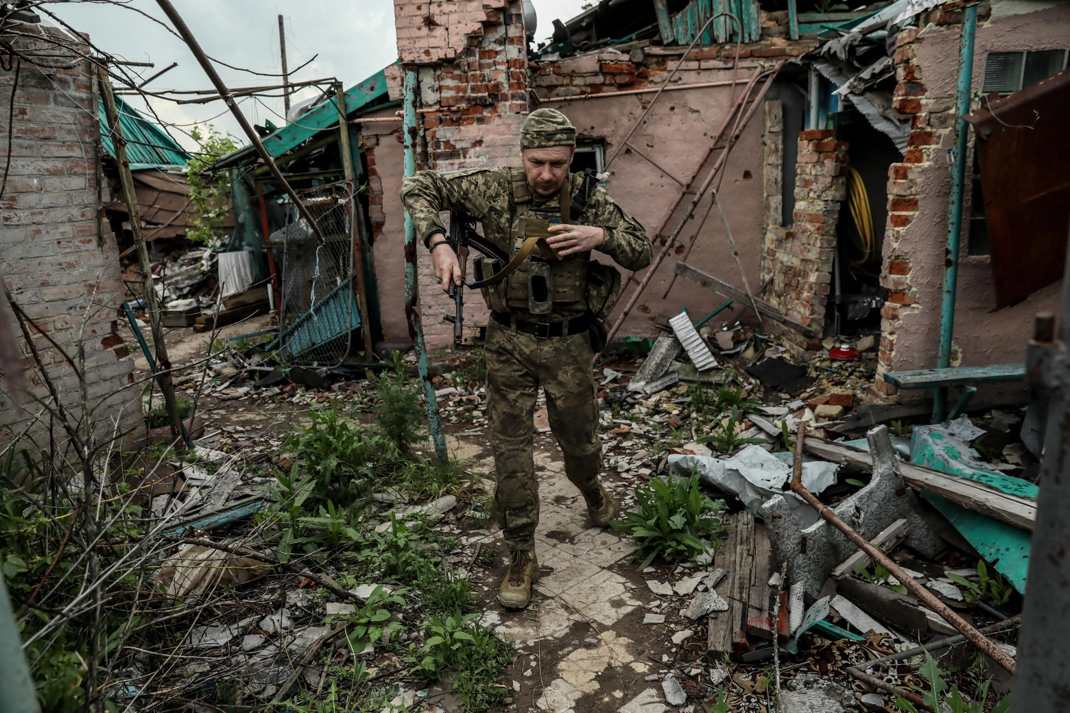 Un soldato ucraino cammina tra i detriti di una postazione di prima linea nel Donetsk (Ansa)