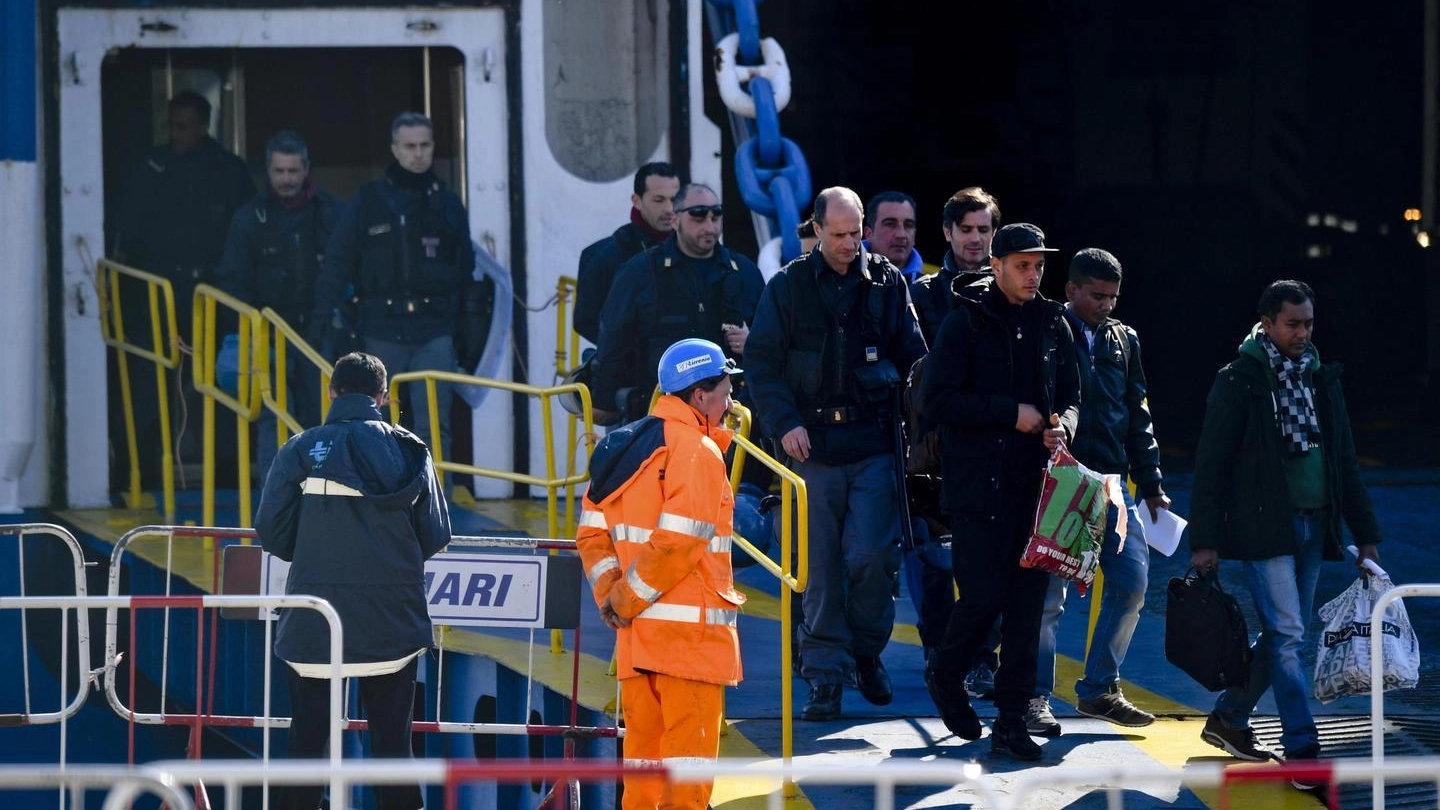 I migranti scortati dalla polizia all'arrivo a Napoli (Ansa)